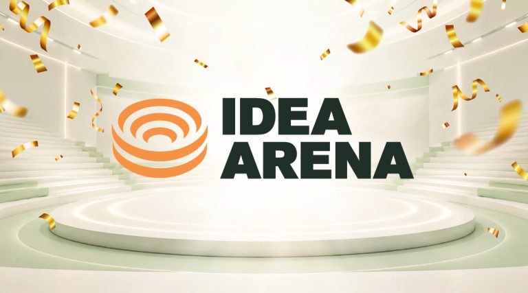 Idea Arena launch banner: the Idea Arena logo set inside a cream-toned amphitheatre with a central lit podium and gold confetti.